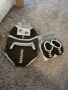 a crocheted football hat and mitt laying on the floor next to a package