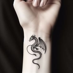 a woman's wrist tattoo with a black dragon on the left side of her arm