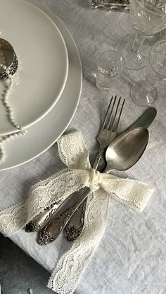 the table is set with silverware and lace