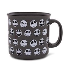 a black coffee mug with jack skellingy faces on it