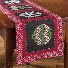 a christmas table runner on top of a wooden table