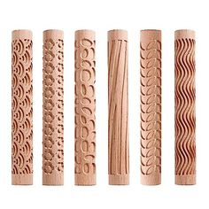 four carved wooden posts lined up in a row on a white background, each with an intricate design