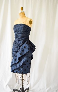 1980s Dress | Louis Feraud | Vintage 80s Midnight Blue Polka Dot Silk Taffeta Strapless Ruched Party Mini Dress Eighties Designer DETAILS: *1980s era dress *Silk taffeta in midnight blue with black flocked velvet polka dots *Strapless ruched bodice *Boning in bodice *Dramatic asymmetrical ruffles *Back zipper *Fully lined LABEL: Louis Feraud  CONDITION: Excellent - some hard distinguish black marks on back of skirt near hem (see photo)  MEASUREMENTS: Bust= 36" Waist= 29" Hips= 40" Length from neckline to hem=33" Compare with your own measurements + ease or compare with similar garments in your closet.  SHIPPING: This item will ship via USPS Priority Mail domestically and international. All orders have insurance included. NOTE: ALL SALES ARE FINAL. Items are freshly cleaned and ready to wea Louis Feraud, Party Mini Dress, 1980s Dresses, Silk Taffeta, Dress Silk, Ruched Bodice, Blue Polka Dots, Asymmetrical Dress, Mini Dress Party