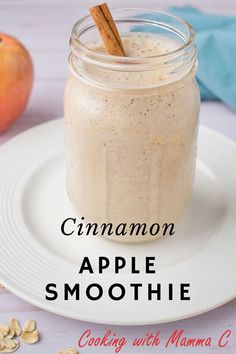 cinnamon apple smoothie in a mason jar on a white plate with an apple next to it