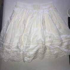 Stretchy White Lace Skirt. Lace Detail At The Button. No Shorts Underneath. White Cloth Layer Underneath. Never Worn. Great Quality And Very Comfortable Casual Mini Skirt With Lace Trim, Daywear Mini Skirt With Lace Trim, Vintage White Skirted Bottoms, White Flowy A-line Mini Skirt, White Skirt Fairycore, White Beach Skirt With Lace Trim, Flowy Lace-trimmed Skirt, White Flowy Skirt, White Lace Skirt