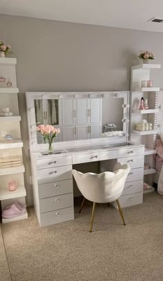 a white desk and chair in a room with shelving, shelves, and drawers