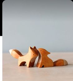 two wooden toy animals sitting next to each other