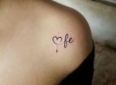 a woman with a small tattoo on her shoulder that reads life and has a heart in the middle