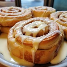 several cinnamon rolls with icing on a plate