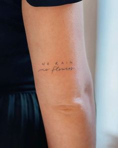 a woman's arm with the words no rain, no flowers written on it