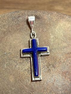 This is a beautiful, vintage, genuine, handmade Zuni lapis lazuli and sterling silver cross pendant that is handmade by Zuni artisan Mike Simplicio. The cross is unisex - for a man or woman. The dainty cross pendant measures about 1 1/2" by 5/8" (About 1 1/8" in length without its bale). The sterling silver bale was recently added as the pendant did not have a bale, and can easily be replaced. The bale opening is about 1/4" in length. The natural lapis stones are vibrant and stunning in a deep c Blue Cross Spiritual Jewelry, Turquoise Sterling Silver Cross Pendant Jewelry, Blue Sterling Silver Crucifix Jewelry, Blue Spiritual Cross Jewelry, Blue Sterling Silver Cross Pendant Necklace, Handmade Blue Crucifix Jewelry, Bohemian Blue Cross Pendant Necklace, Vintage Lapis Lazuli Jewelry For Gifts, Silver Bohemian Lapis Lazuli Necklaces