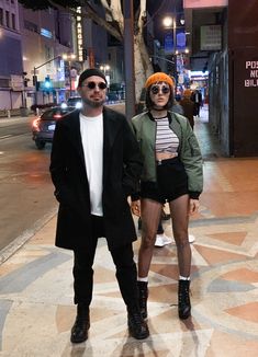 a man and woman standing on the sidewalk