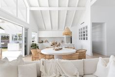 a living room filled with furniture and a white table surrounded by pillows on top of it