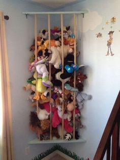 a bunch of stuffed animals are hanging on the wall in this child's room