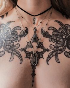 a close up of a woman's chest with tattoos on it