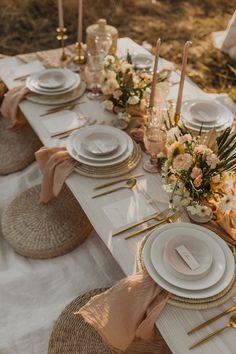 the table is set with white plates and place settings