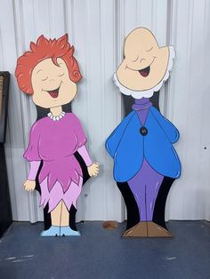 two cardboard cut outs of cartoon characters standing next to each other in front of a wall