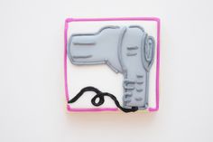 a cookie shaped like a blow dryer on top of a white surface with pink trim