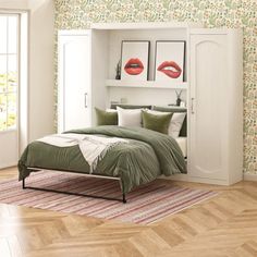 a bedroom with green and white wallpaper has a bed in the corner, two red lips on the wall