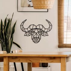 a dining room table with chairs and a wall mounted bull head on the wall above it