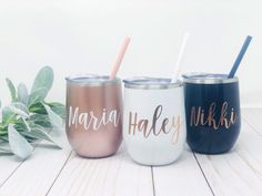 three personalized tumblers with straws on them sitting next to some plants and leaves