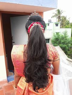 the back of a woman's head with long black hair wearing a tiara