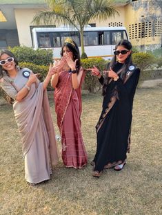 three women in sari are posing for the camera