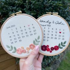 two embroidery hoops with flowers on them, one has a date and the other is hand embroidered