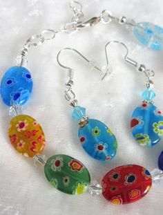 This multi-colored adjustable millefiori bracelet set is made with 14mm flat ovals and includes blue, red, orange, and green multi-colored beads. The bracelet adjusts from 7 inches to 8 inches. The earrings dangle 1 inch from the loops of the silver plated ear wires. This set will be slipped into an organza bag and shipped in a bubble mailer. Adjustable Multicolor Czech Glass Jewelry, Adjustable Multicolor Bracelets With Oval Beads, Adjustable Multicolor Oval Bracelets, Adjustable Oval Multicolor Bracelets, Multicolor Czech Glass Jewelry With Oval Beads, Oval Earring, Ear Wires, Organza Bags, Bracelet Set