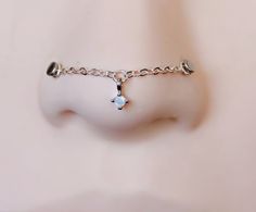 a close up view of a nose with a chain around it and a cross on the side