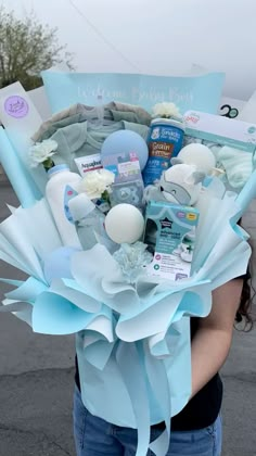 a woman holding a bouquet of baby items