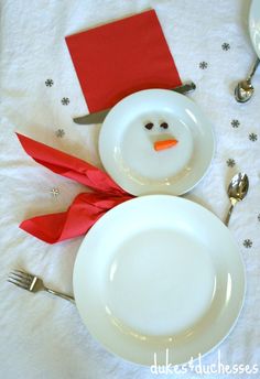 a white plate topped with a snowman on top of a table next to utensils