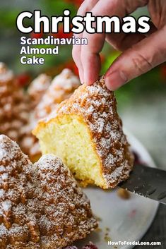 someone is holding a piece of cake with powdered sugar on it and the rest of the cake has been cut in half