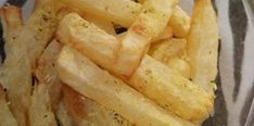 french fries in a glass bowl with seasoning on top