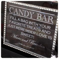 the candy bar sign is next to other candies and sweets on display in glass vases