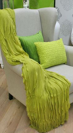 a chair with some green pillows on it