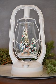 a christmas tree in a snow globe on top of a table