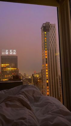 an image of a city skyline seen through a window at night from a hotel room