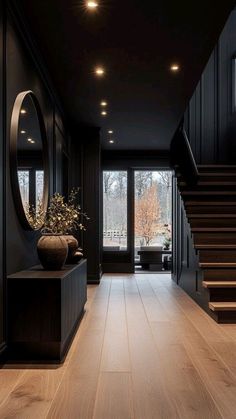 an empty hallway with wooden floors and black walls