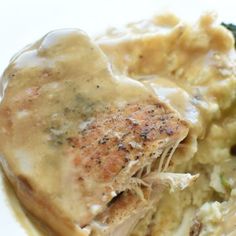 a close up of food on a plate with broccoli and gravy