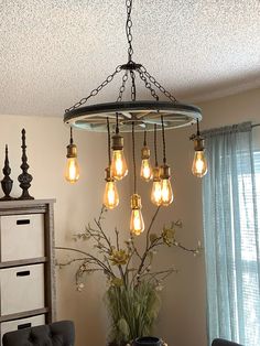 a chandelier hanging from the ceiling in a room with chairs and a table