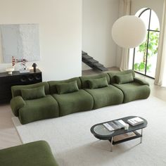 a living room filled with furniture next to a large white rug on top of a hard wood floor