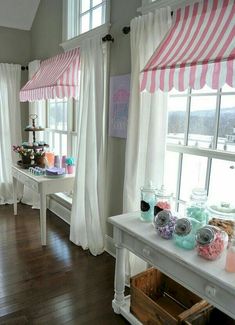 a room filled with lots of windows covered in pink and white curtains