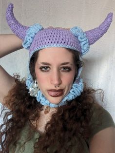 a woman wearing a knitted hat with horns on her head