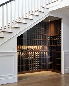 a wine cellar under the stairs in a house