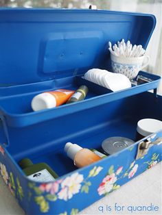 two blue containers with toothbrushes and other items in them