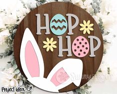 a wooden sign that says hop hop with an easter egg and bunny ears on it