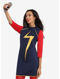 a woman in a blue and red dress holding up a cell phone with a lightning symbol on it