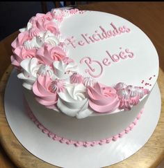 a birthday cake with pink and white frosting on a wooden platter that says happy birthday belies