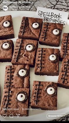 some brownies with googly eyes are on a white plate and there is a sign that says spell book browns